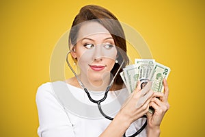 Woman with stethoscope listening to dollar bills making analysis of moneyÃ¢â¬Â investment